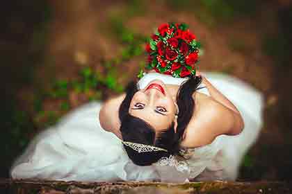 A Colombian woman in her white wedding dress holding a bouquet of roses