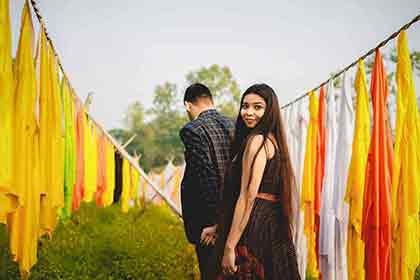 A photo of a couple holding hands as the man leads the way while the woman is looking back