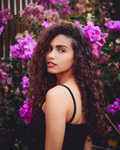 A Latina with a pink flower background