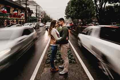  A photo of a happy couple facing each other in the middle of the road