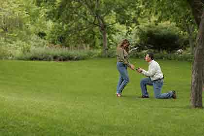 A photo of a man down on one knee, proposing to a woman