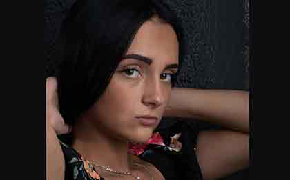  A photo of a beautiful Colombian girl wearing a floral top, holding her hair back