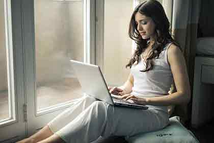 A hot Colombian woman smile while using her laptop